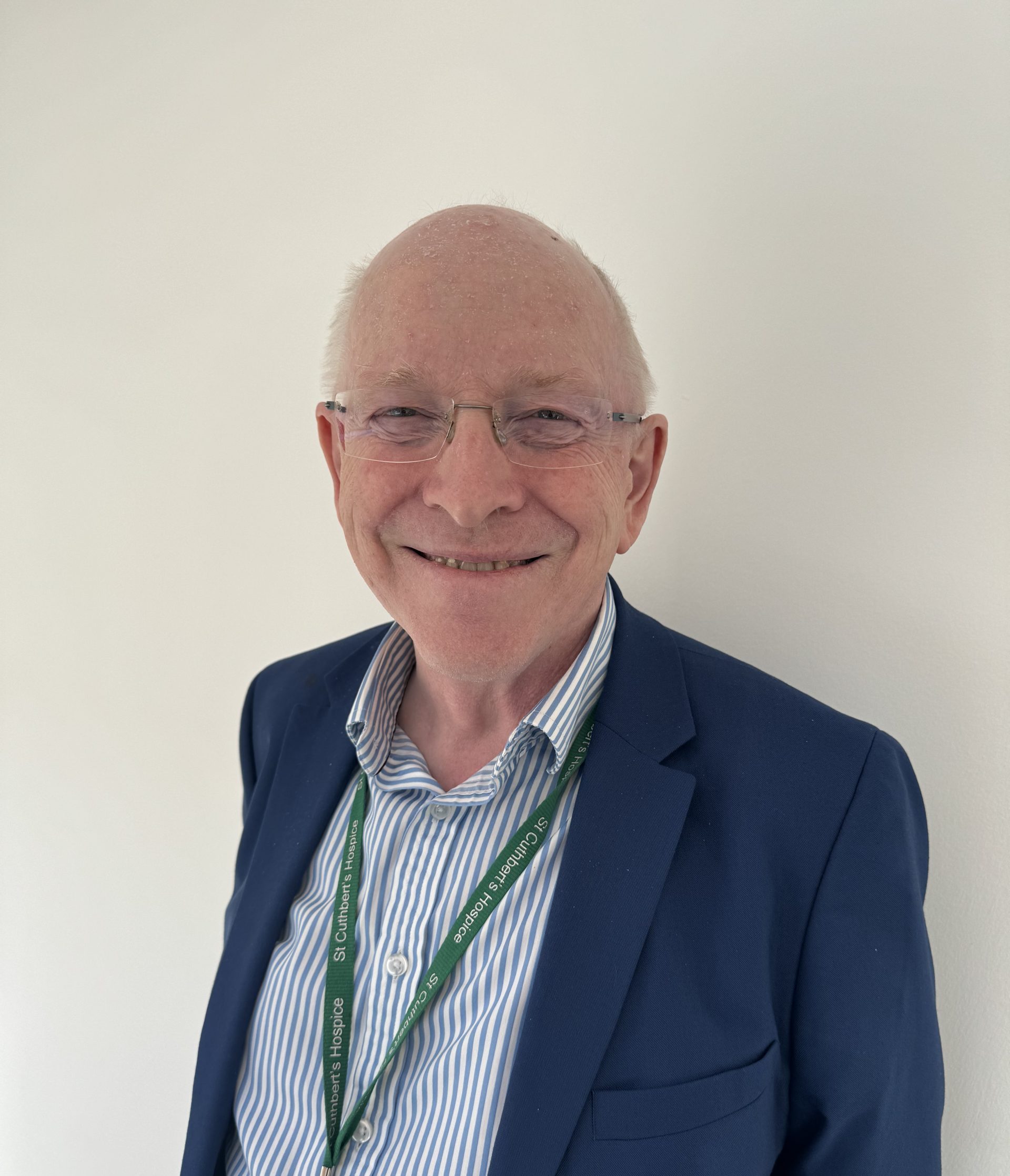 A smiling man in a suit and lanyard embodies professionalism and friendliness, creating a positive impression.